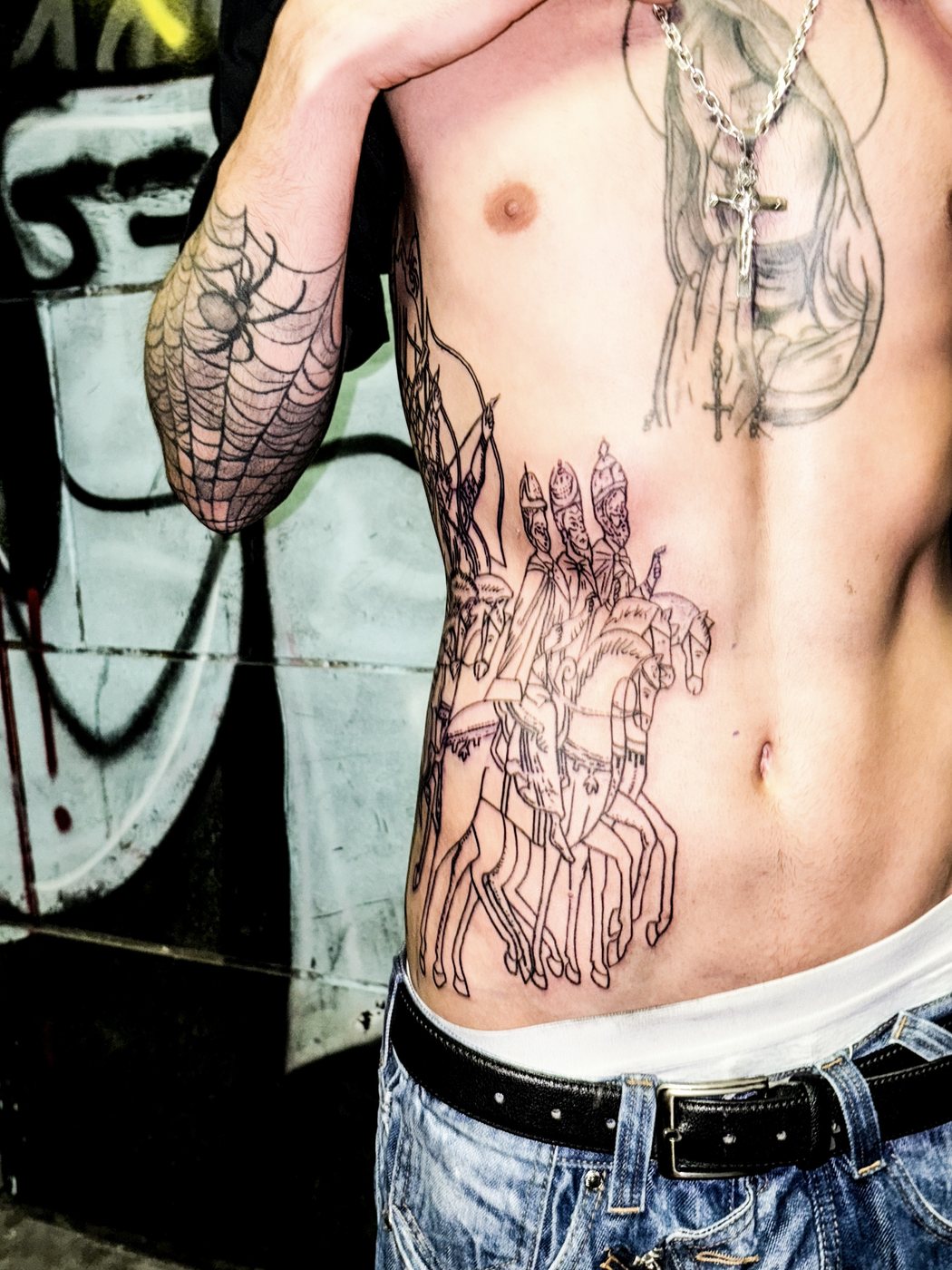 horsemen piece across the ribs, healed, shot against a graffiti wall